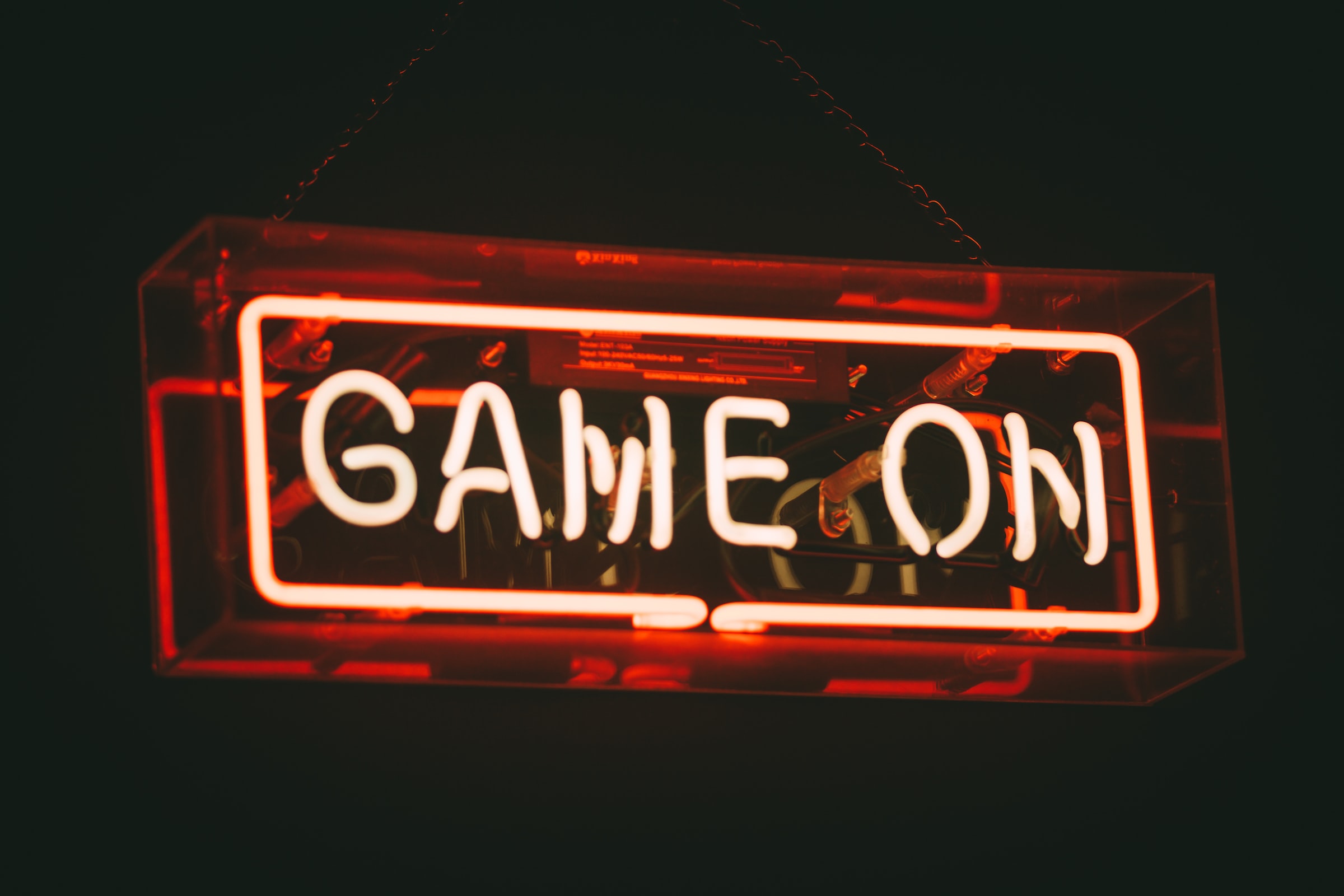 Прозрачный прямоугольник на черном фоне со светодиодной подсветкой, на нем написано “Game on”.