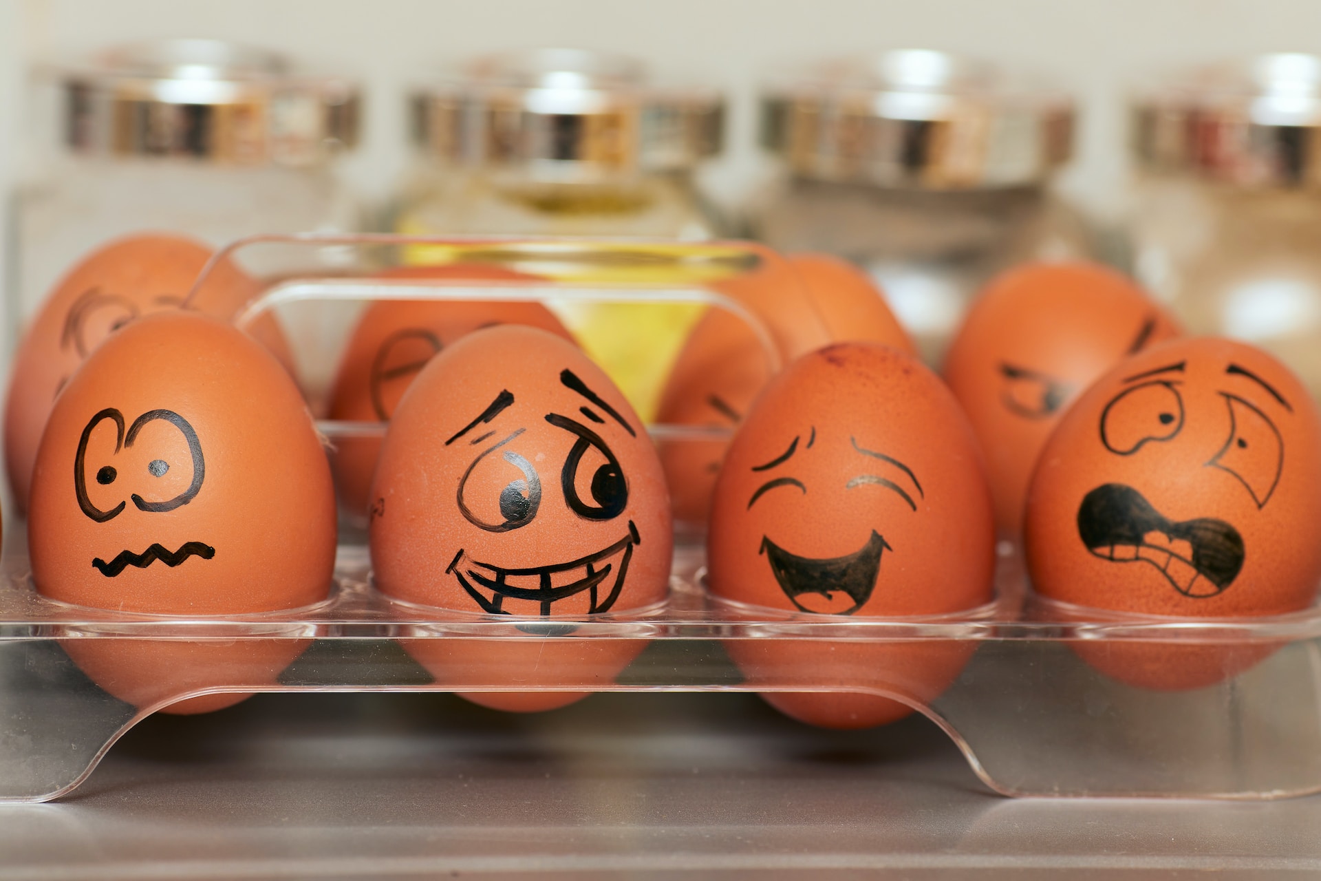 Есть восемь яиц с разными нарисованными лицами, демонстрирующими разные эмоции и настроение.
