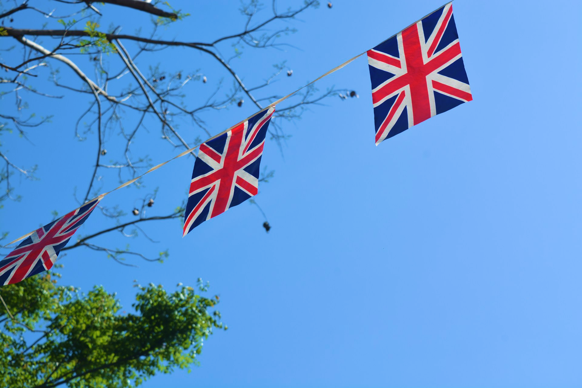 There are some small British flags in a blue sky
