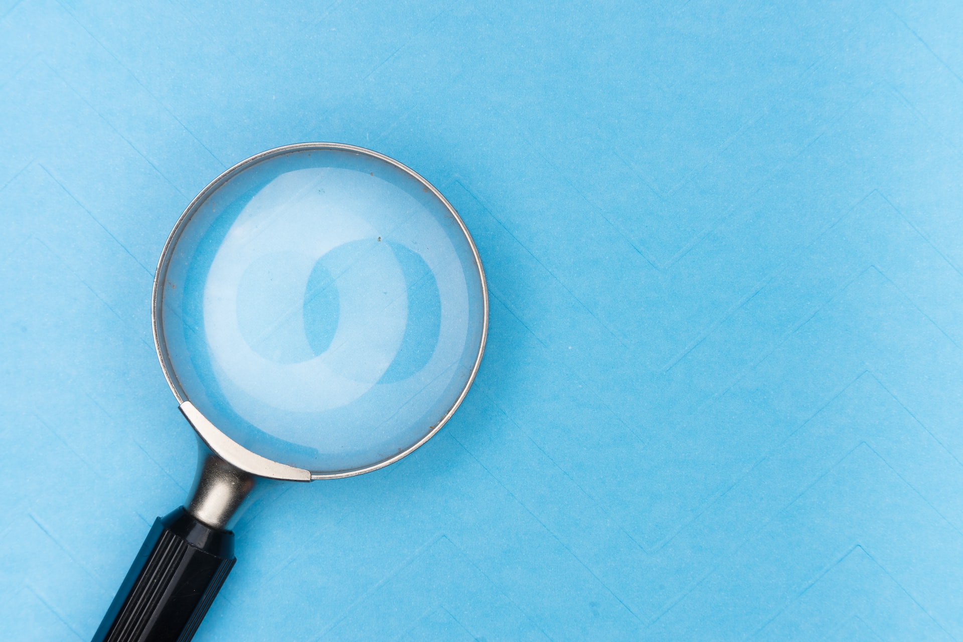 A magnifying glass on light blue background